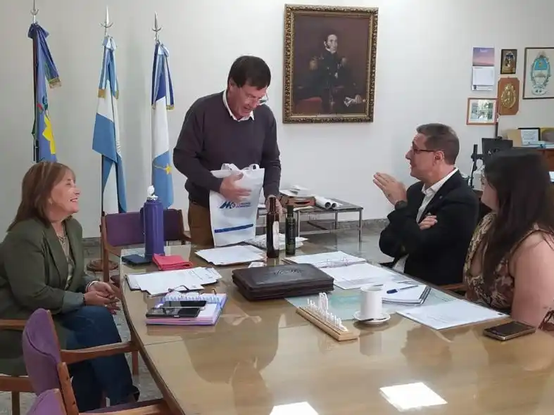 El profesor Hernán Piotti López recibe un presente (aceites de oliva) de manos del intendente Juan Carlos Chalde