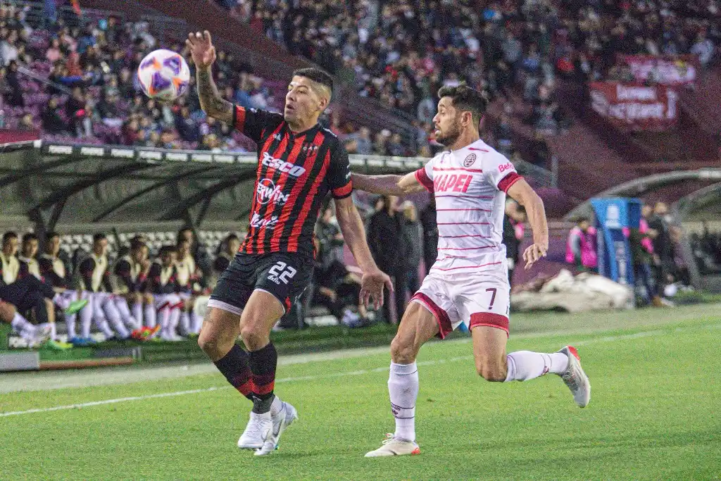 Lozano cubre la pelota ante Acosta.