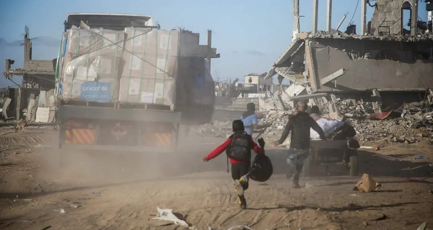 Palestinos corren hacia los camiones de ayuda humanitaria, en Rafah, en el sur de la Franja de Gaza. Foto: REUTERS / Hatem Khaled.