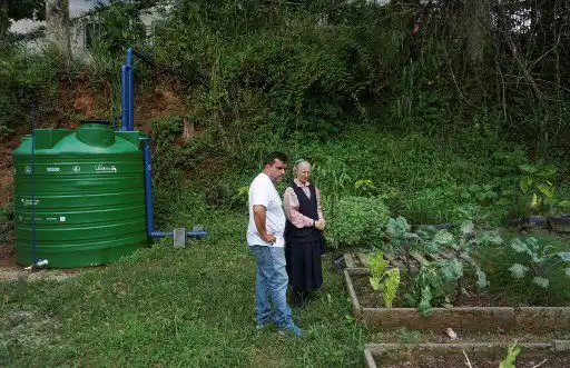 El director del proyecto "Lata de Agua", Laurencio Sánchez (L), y la monja María Inés Guerreiro observan la huerta de la escuela Unidad Educativa Nuestra Señora del Encuentro, beneficiaria del programa "Lata de Agua", en la populosa barrio de Petare en Caracas