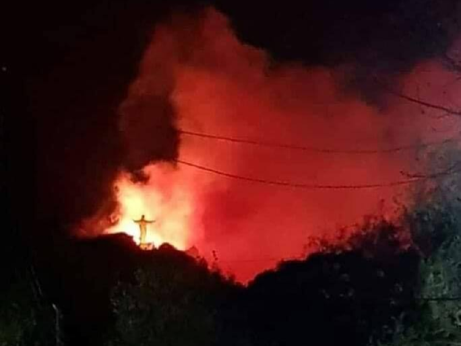 El Cristo Redentor de La Cumbre iluminado por el fuego en las Sierras