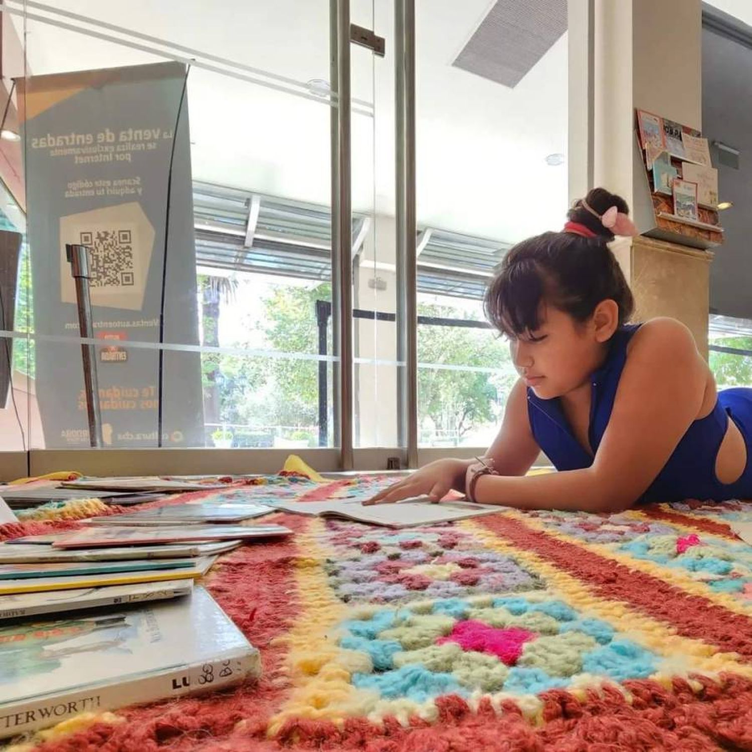 Niña leyendo sobre una alfombra de lana