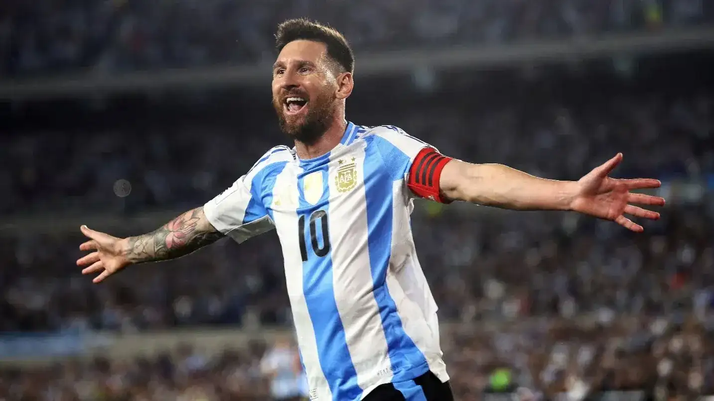 Lionel Messi celebra un gol con la camiseta de la Selección Argentina, luciendo la cinta de capitán y los brazos abiertos en un gesto de euforia ante el público en una jornada histórica para el fútbol nacional.