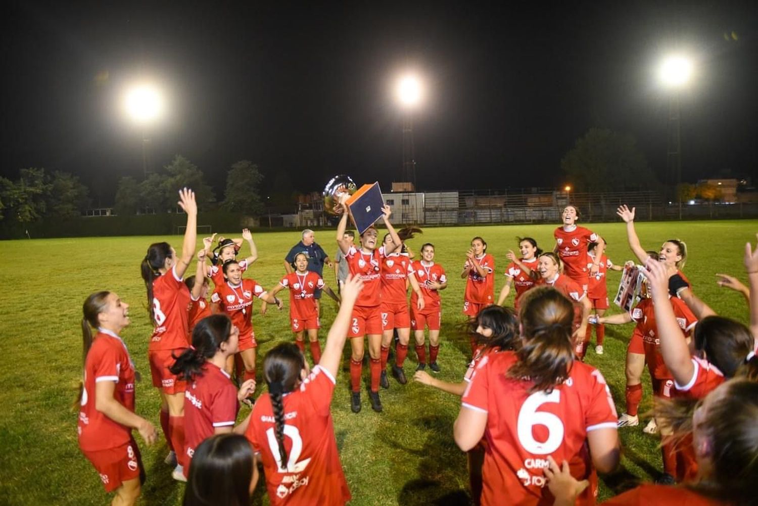 Analía Martínez en el centro de la escena y levantando la copa.