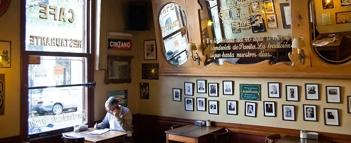 Mesas, retratos y leyendas: el interior del Café Margot mantiene viva la memoria barrial de Boedo y su tradición de cafés como espacios de lectura, escritura y pensamiento.