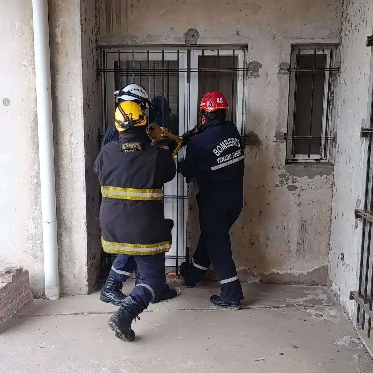 Personal de bomberos intentando abrir la puerta.