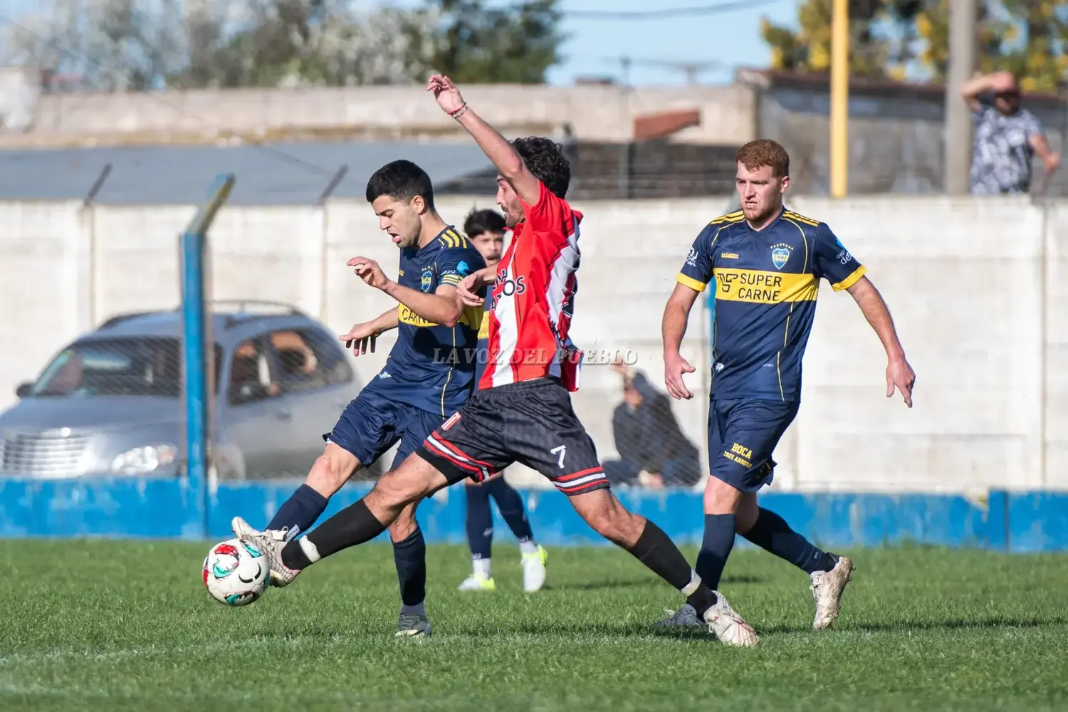 Mouhape de Boca y Knudsen de Quilmes chocan por la pelota mientras mira Ruschetti