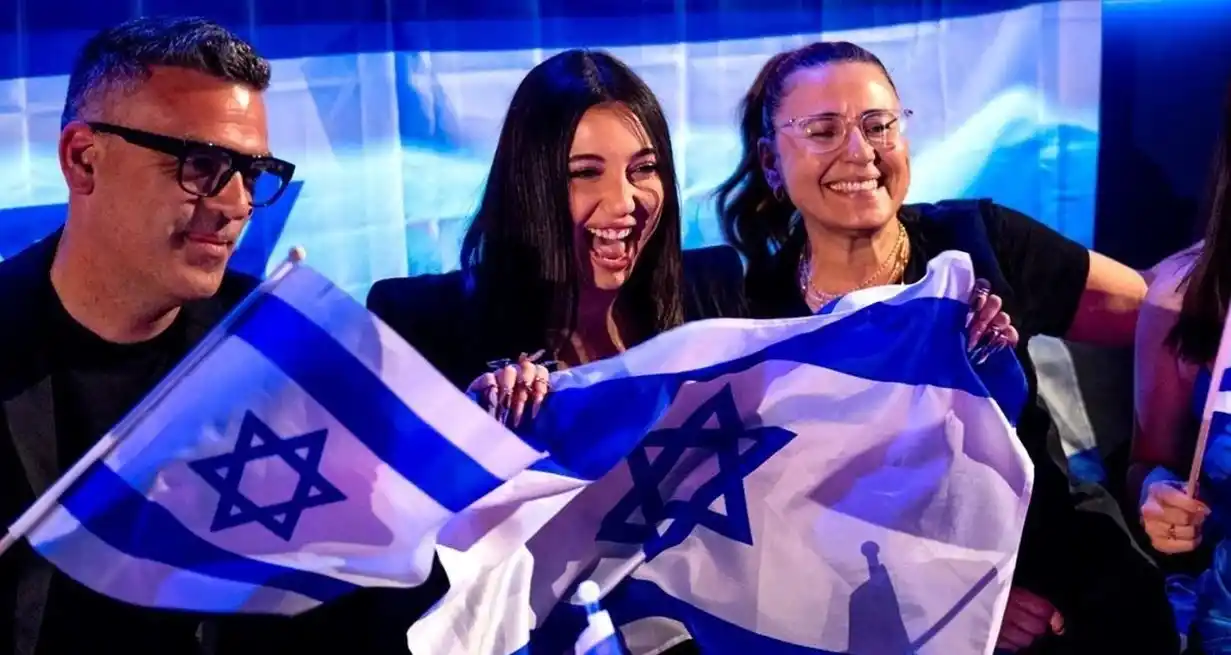 La intérprete israelí Yuval Raphael, en el centro de la imagen, festeja en Basilea (Suiza) con la bandera de su país el segundo puesto obtenido en Eurovisión 2025.