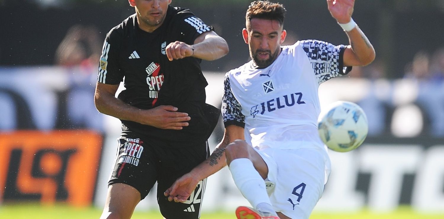 Mauricio Isla contra la pelota ante la marca de un jugadores de Riestra (Crédito: Baires)