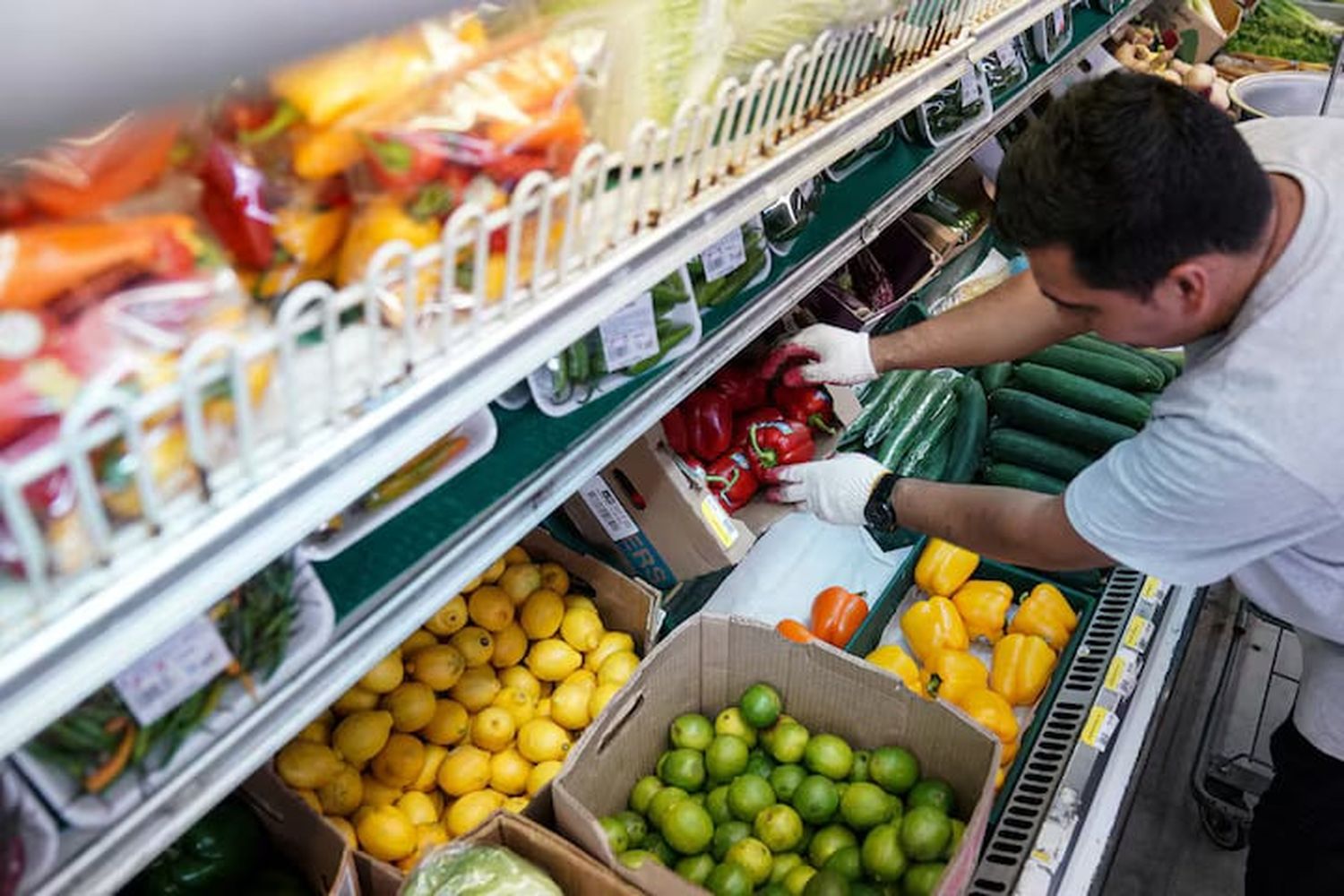 A man arranges produce at Best World Supermarket in the Mount Pleasant neighborhood of Washington, D.C., U.S., August 19, 2022.