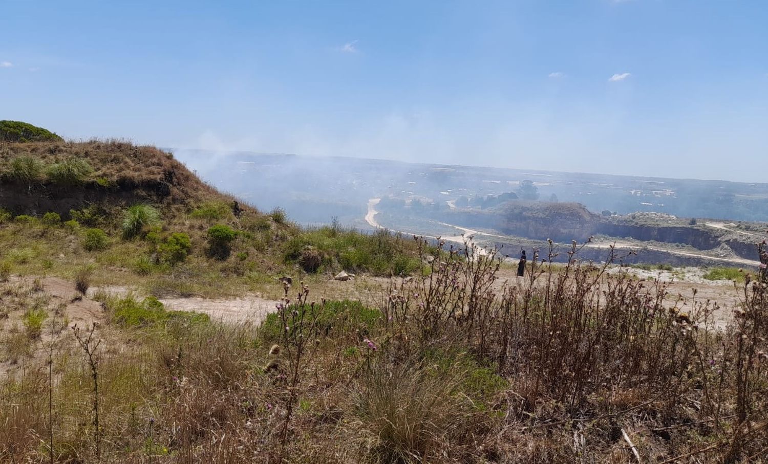 Bomberos trabajan en un incendio de malezas en la zona de Batán