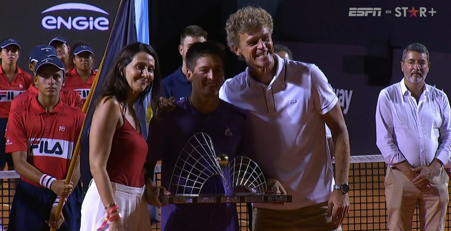 El extenista brasileño, Gustavo Kuerten, entregándole el trofeo a Báez.