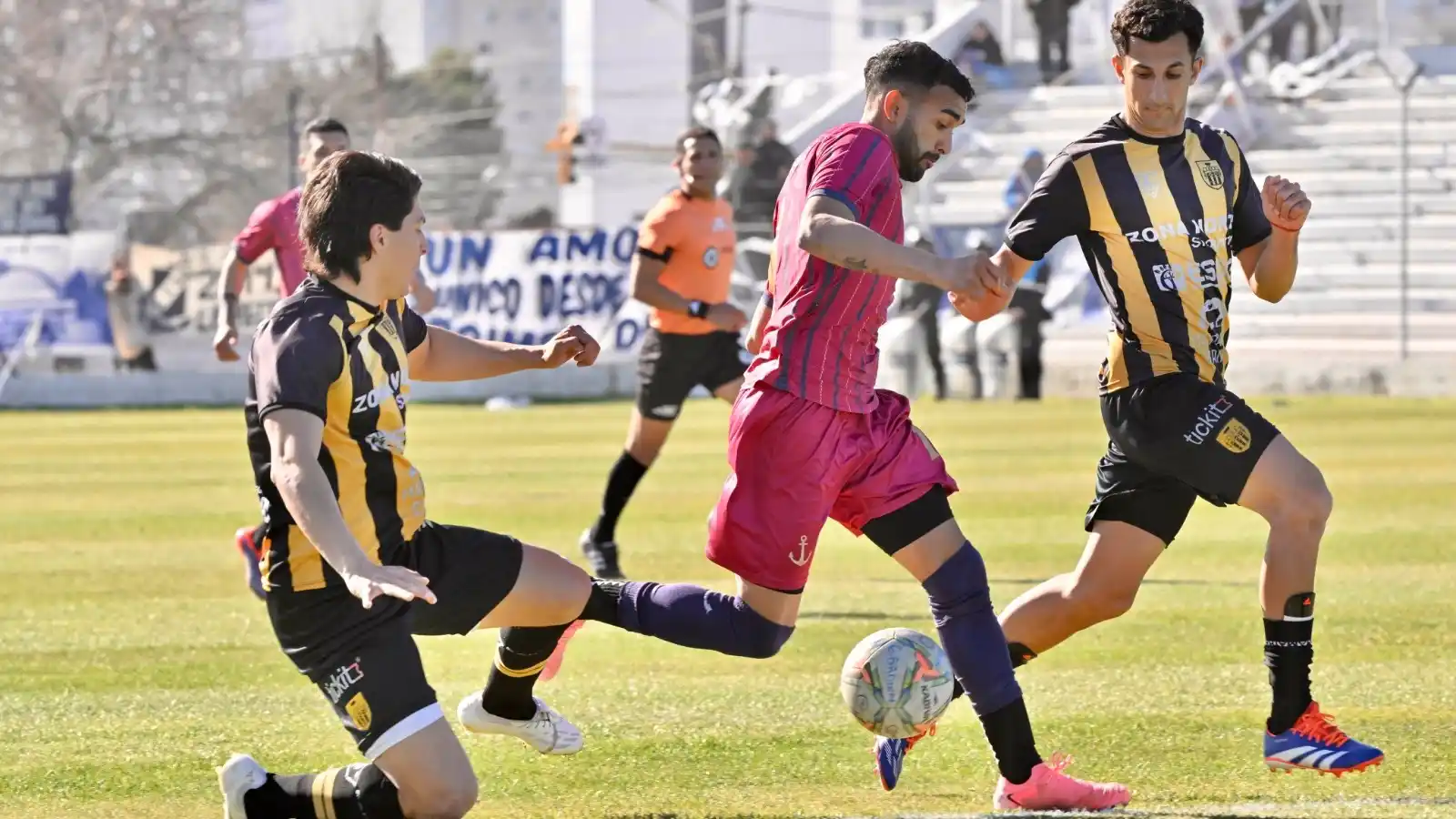 FOTO @FELDMAN_DA-DIARIO JORNADA Romero y Valenzuela, intentando frenar a González, en la derrota de Santamarina en Puerto Madryn.