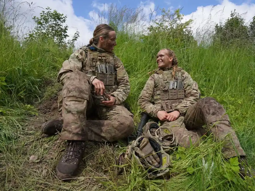 Katrine, de 20 años, a la derecha, habla con otra mujer militar durante los ejercicios finales en un campo de entrenamiento cercano al cuartel del Ejército Real Danés en Hovelte.