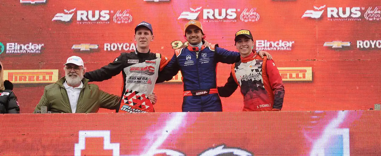 Melo festeja en el podio, con Bayala a su derecha.