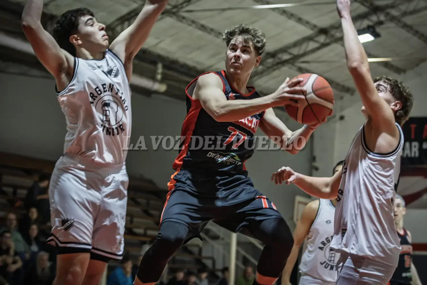 Brian Milobara de Huracán de Necochea, mantiene la pelota dentro del perímetro ante la marca de Argentino