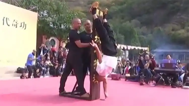 Un monje de Shaolín mantiene su cuerpo cabeza abajo con la ayuda de un solo dedo