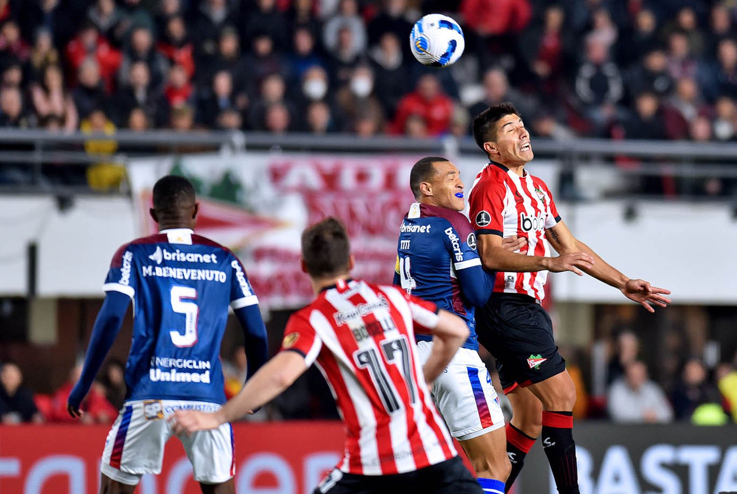 Lollo se impone arriba ante Titi, con Marcelo Benvenuto y Boselli siguiendo la acción.