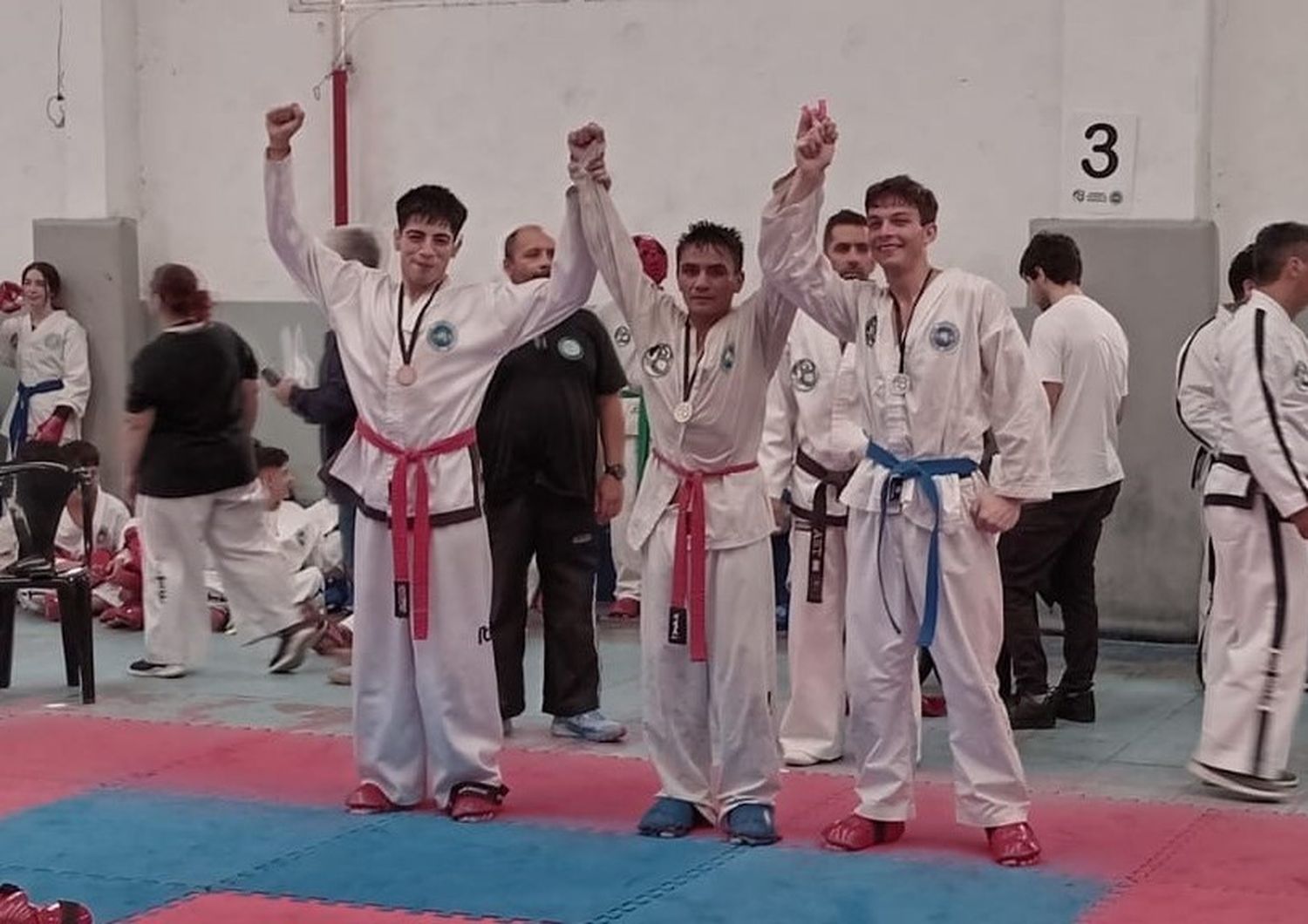 Mario Montiel (en el centro) con su medalla de oro