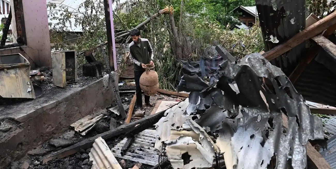 Un hombre recoge sus pertenencias en su vivienda en Salamabad que fue dañada durante enfrentamientos. Xinhua/Javed Dar