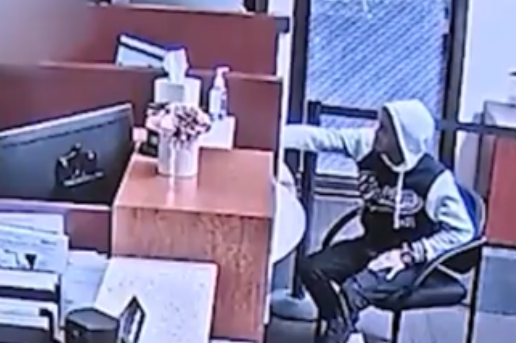 Las imágenes de seguridad muestran al hombre usando su teléfono para comunicar sus solicitudes, que incluían sacar dinero de las cajas y colocarlo en una bolsa.