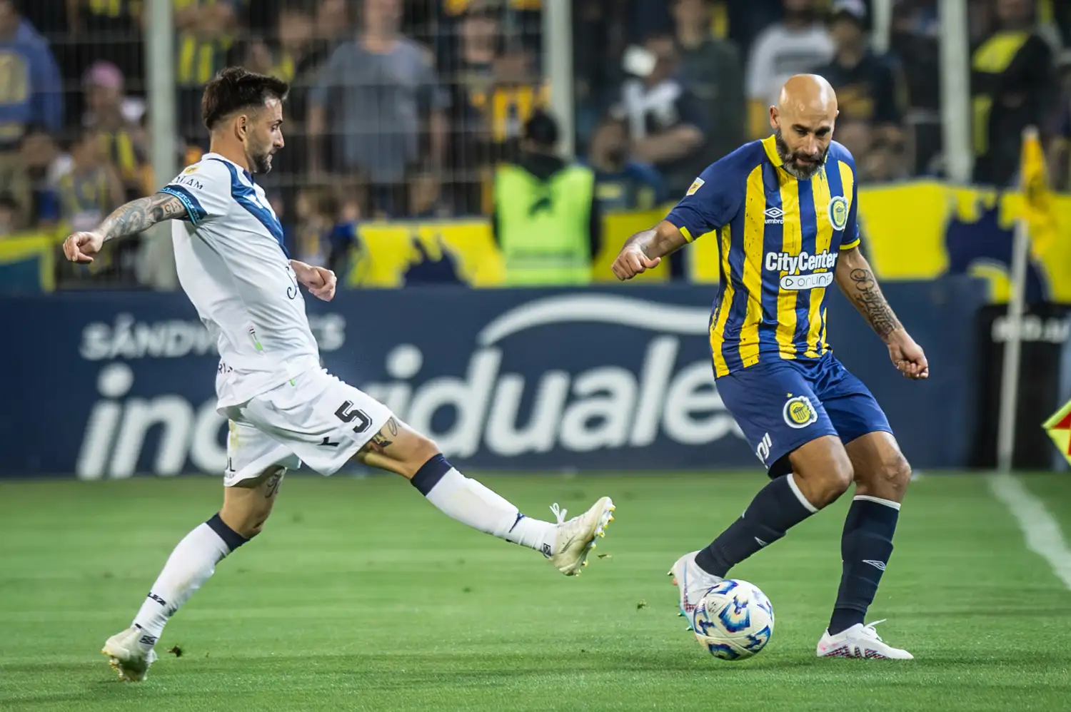La disputa por la pelota es entre Elías y Quintana.