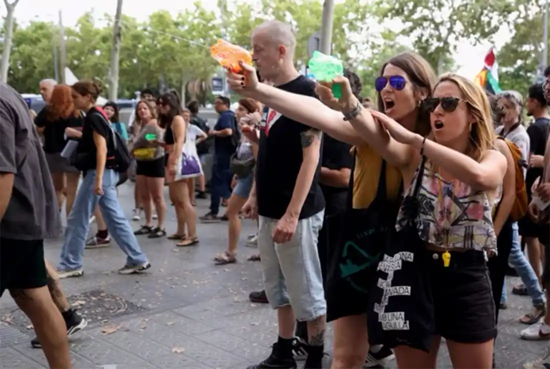 Manifestantes disparan agua con pistolas de agua a los turistas durante una protesta contra el turismo de masas en Barcelona, ​​España.
