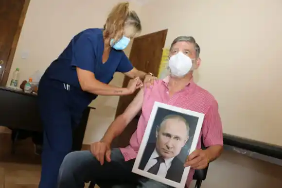 Roque Pérez: Gasparini volvió a la intendencia y se vacunó contra el coronavirus con foto de Vladimir Putin