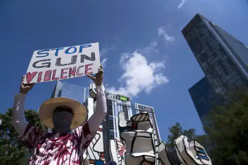 Los defensores del control de armas sostienen carteles durante una protesta en Discovery Green frente a la Reunión Anual de la Asociación Nacional del Rifle en el Centro de Convenciones George R. Brown