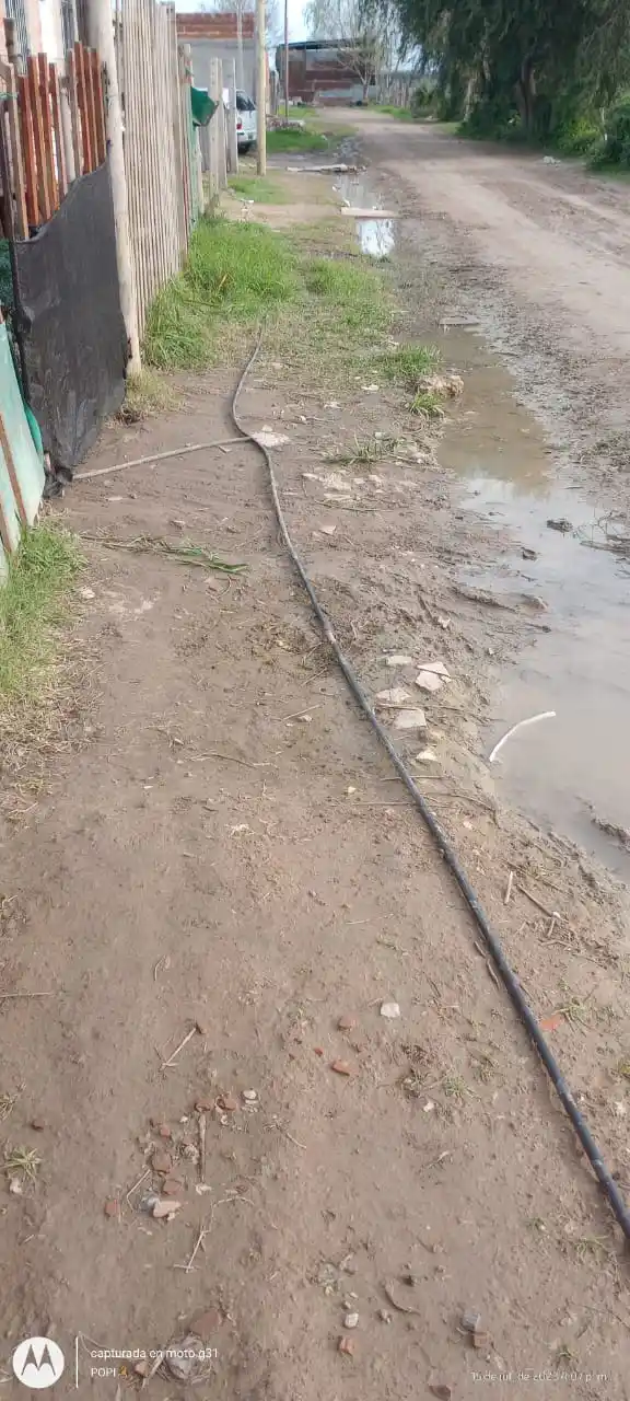 Cable clandestino sobre calle no asfaltada