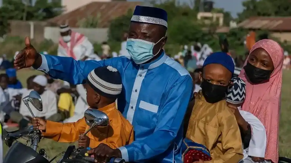 Una familia musulmana llega en motocicleta para asistir a las oraciones de Eid al-Adha en la Escuela Sayo Muhamed en medio de un brote de ébola en Bunia, Congo.