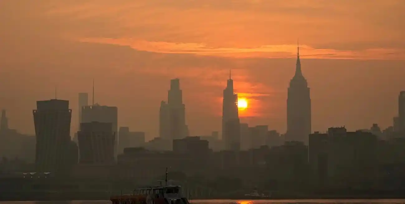 El sol sale detrás del Empire State y del perfil urbano de Nueva York a través de una capa de humo de incendios forestales, visto desde Hoboken, Nueva Jersey. REUTERS/Eduardo Munoz