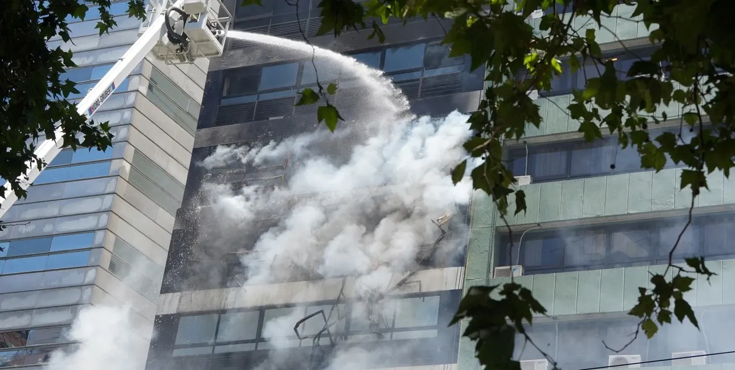 Con una grúa los bomberos apagaban las llamas.