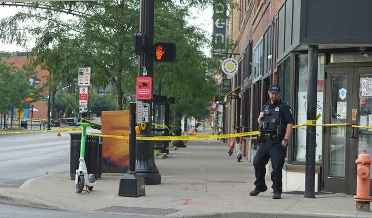 A Columbus police officer keeps the scene secure after 10 people were shot in the Short North area of Columbus overnight.