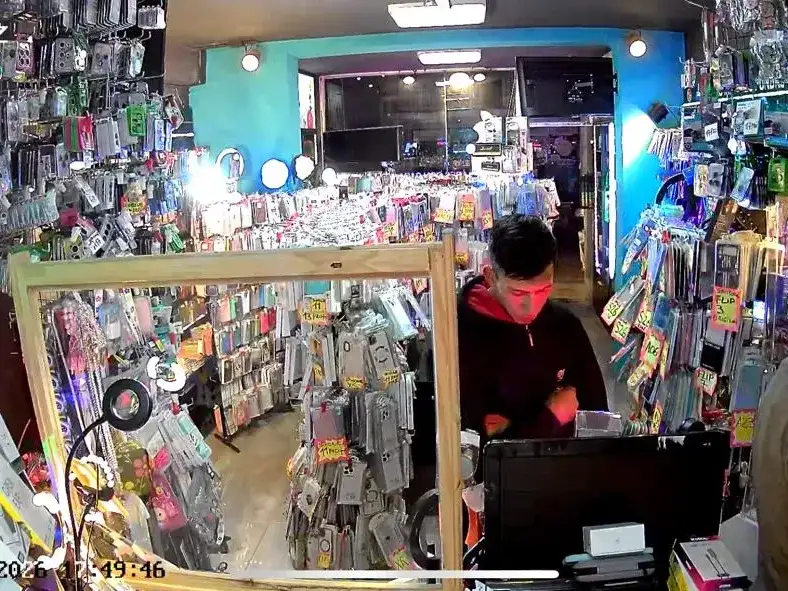 Uno de los autores junto al comerciante. Ambos quedaron registrados por las cámaras del local.