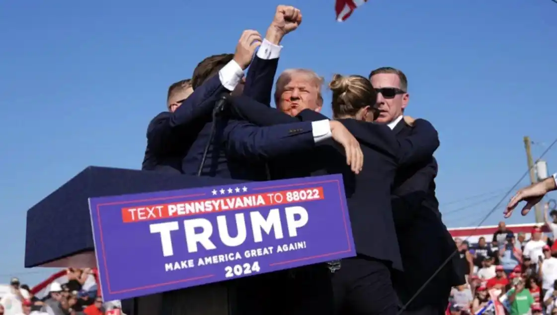 Agentes de seguridad protegen a Trump en medio de las detonaciones.