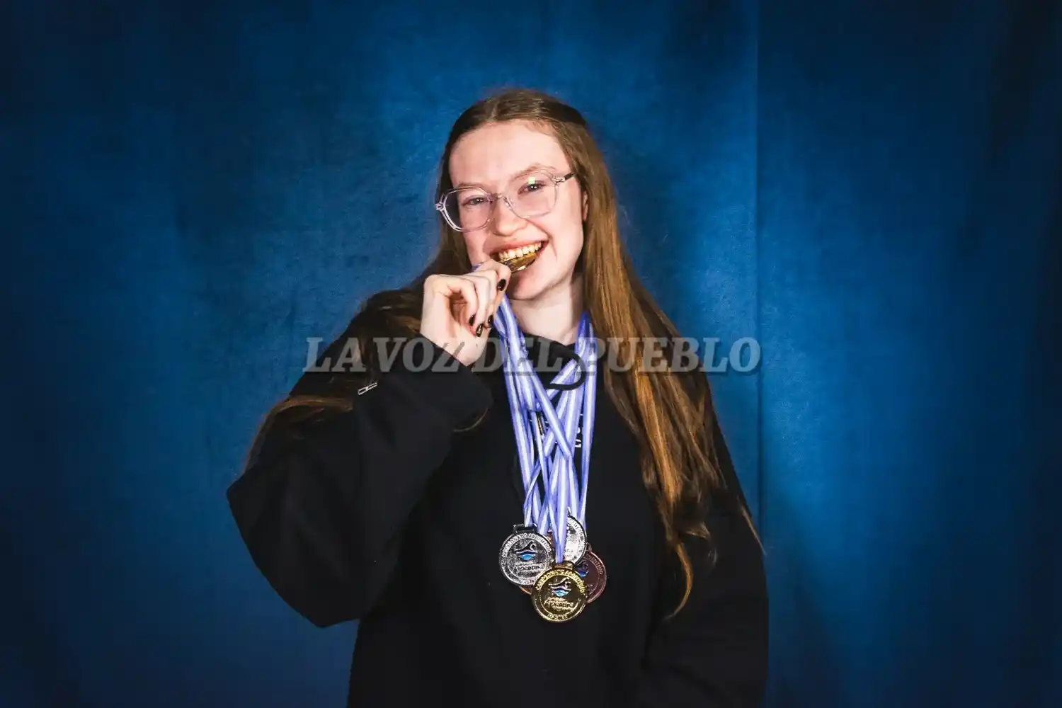 Pierina Marchini junto a sus medallas en la redacción de La Voz del Pueblo
