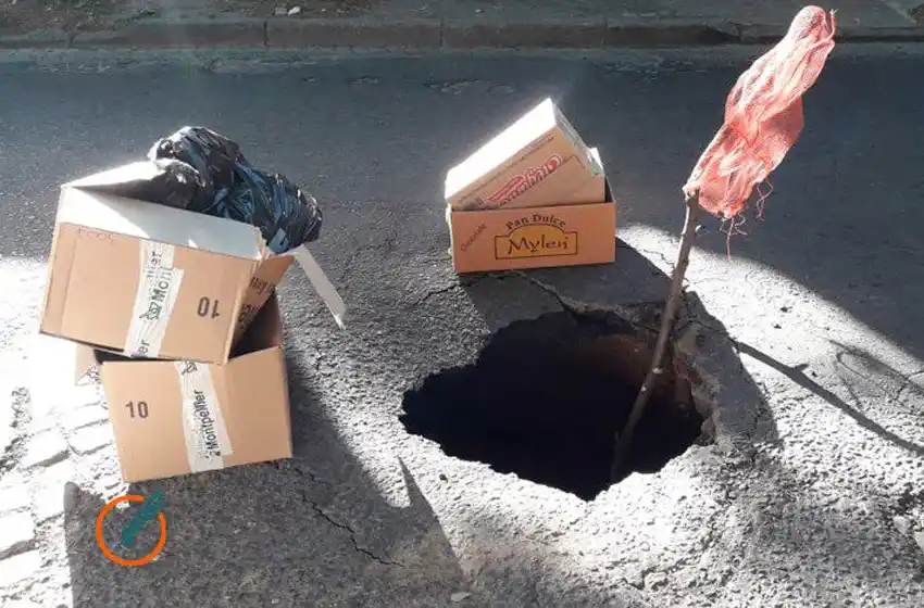 Con palos, bolsas y cartones, vecinos señalizaron un impresionante cráter en la zona centro