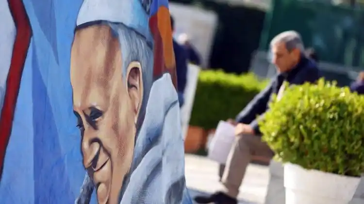 Fieles rezan bajo la estatua de Juan Pablo II en ekl Policlínico Gemelli