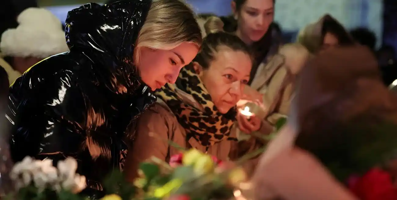 Familiares dejan ofrendas frente a "Le Constellation" este 1 de enero. Reuters