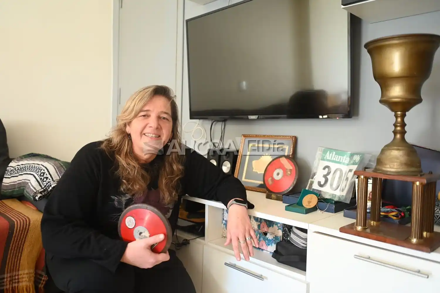 En su casa, Martinelli posa con los discos que usó en Atlanta 96' (crédito: MR Fotografía).