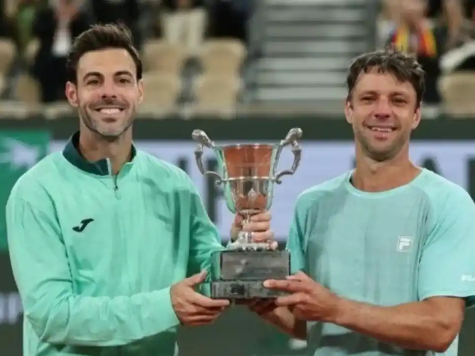 El catalán M.Granollers junto al marplatense "Cebolla" Zeballos alzando el trofeo de campeones de Roland Garros 2026 en doble. Foto: Reuters