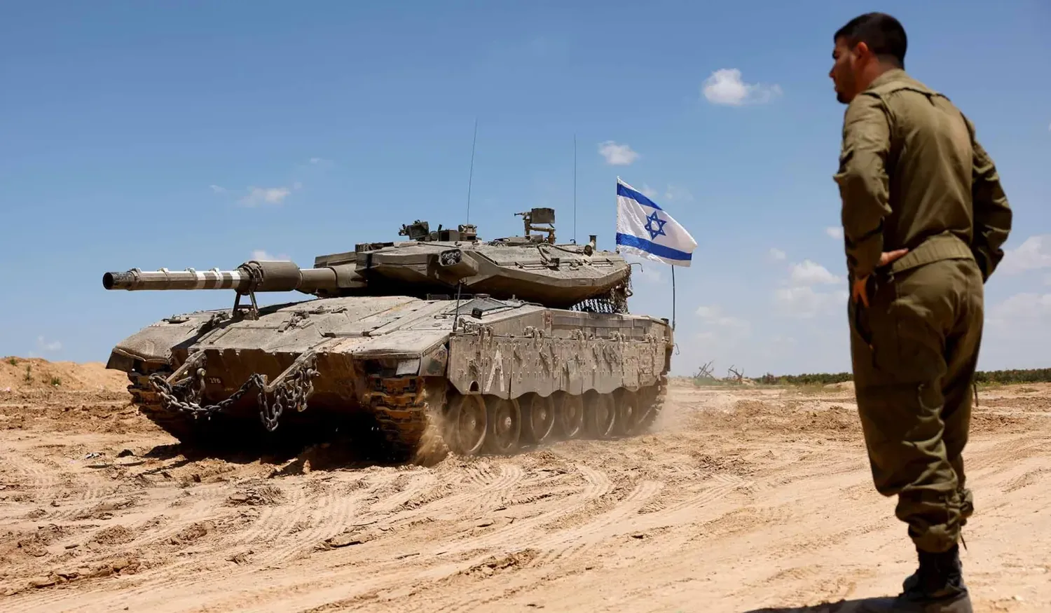 An Israeli soldier stands in a tank, amid the ongoing conflict between Israel and Hamas, near the Israel-Gaza border, in Israel.