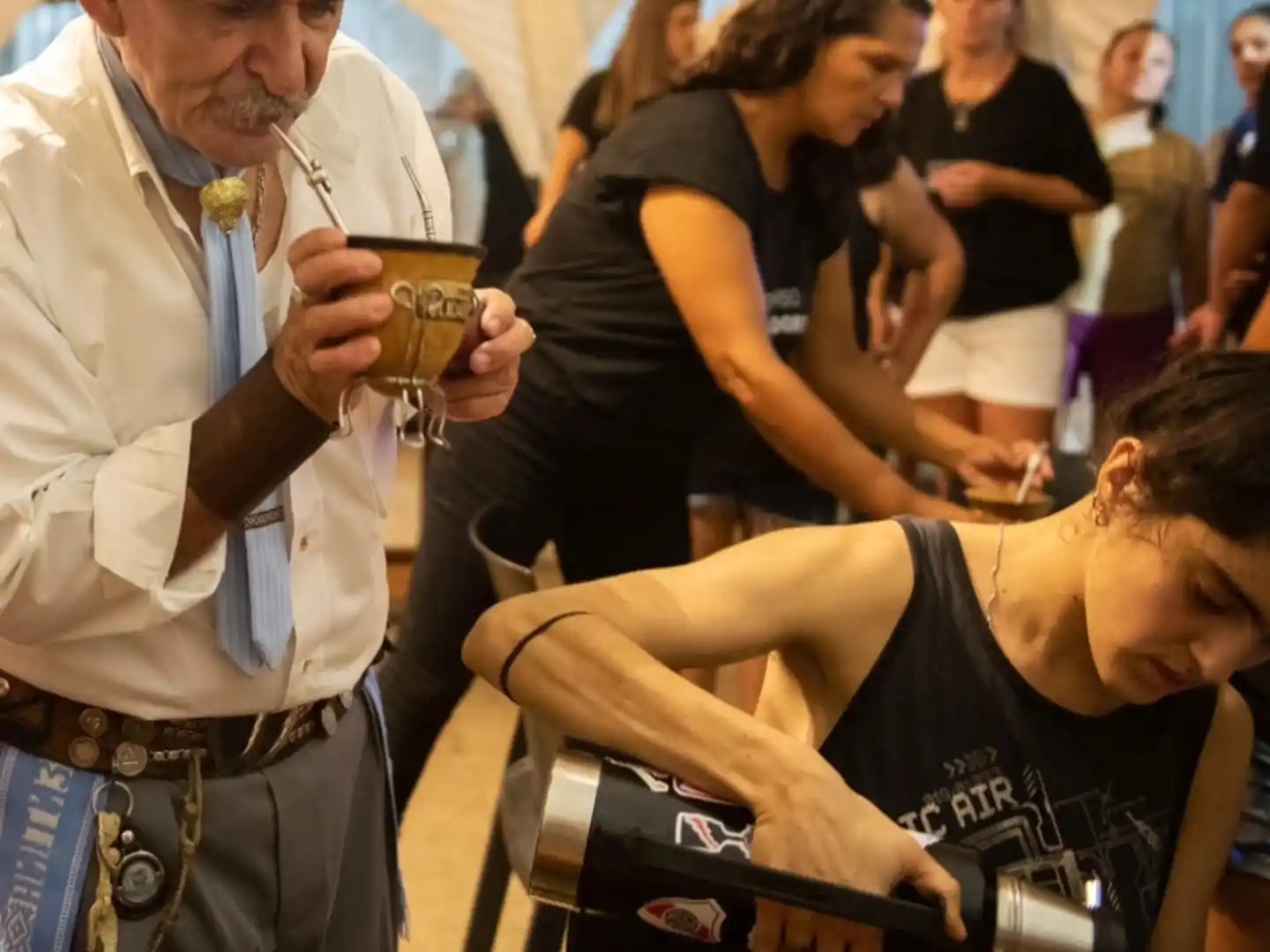 Asistentes disfrutan del mate durante la fiesta.