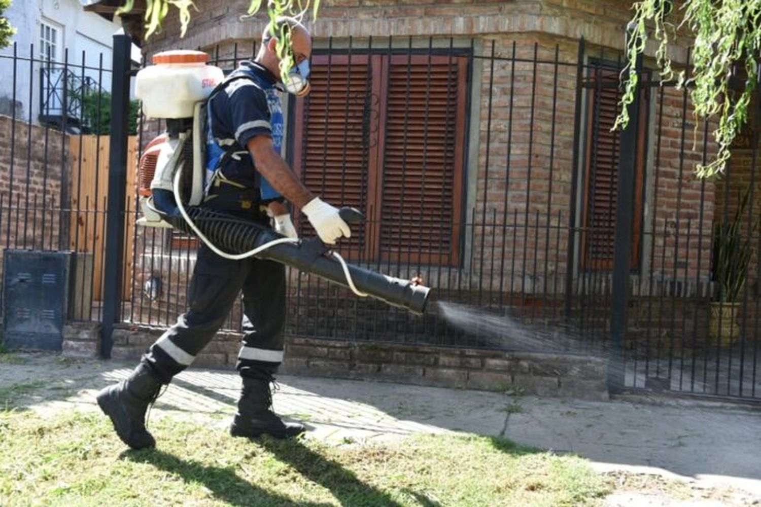 Una persona fumigando contra el dengue.