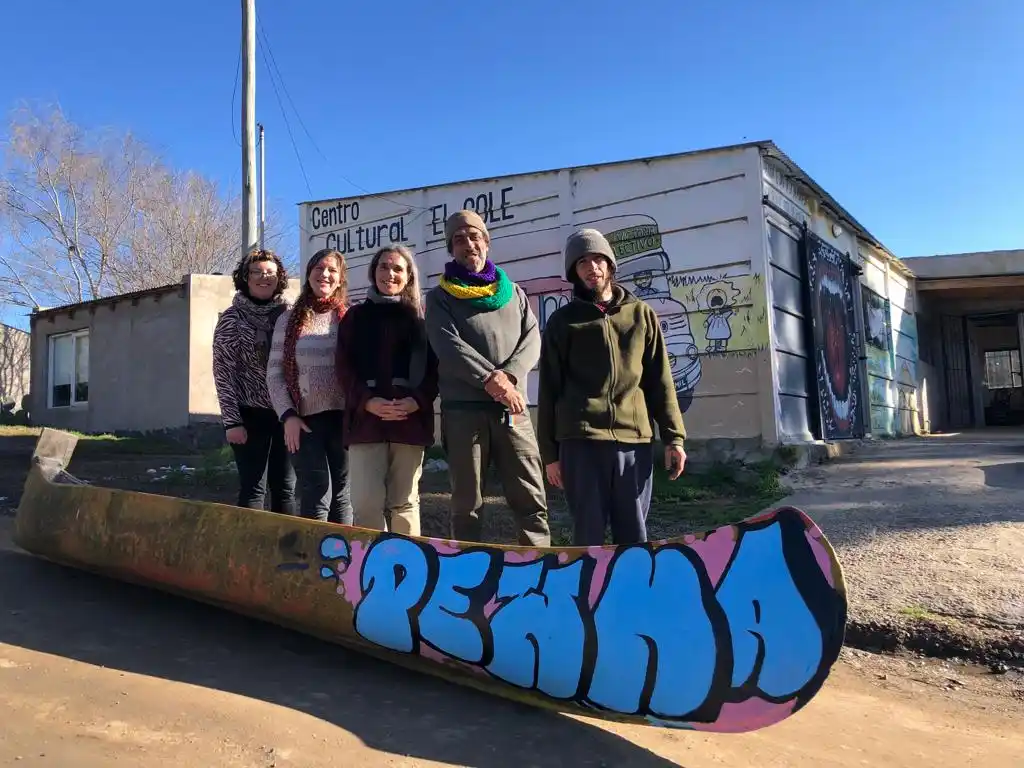 Parte del grupo, junto a la canoa Pewma, intervenida por el joven artista Yaro, oriundo del barrio.