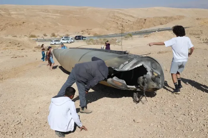 Personas revisan los restos de un misil balístico de Irán en las afueras de la ciudad israelí de Arad, el 2 de octubre de 2024. EFE/Abir Sultan