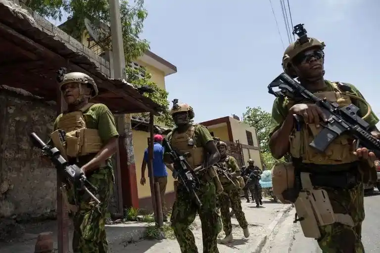 La unidad SWAT de la Policía Nacional de Haití y la Policía de Kenia caminan a través de una empinada colina en Puerto Príncipe