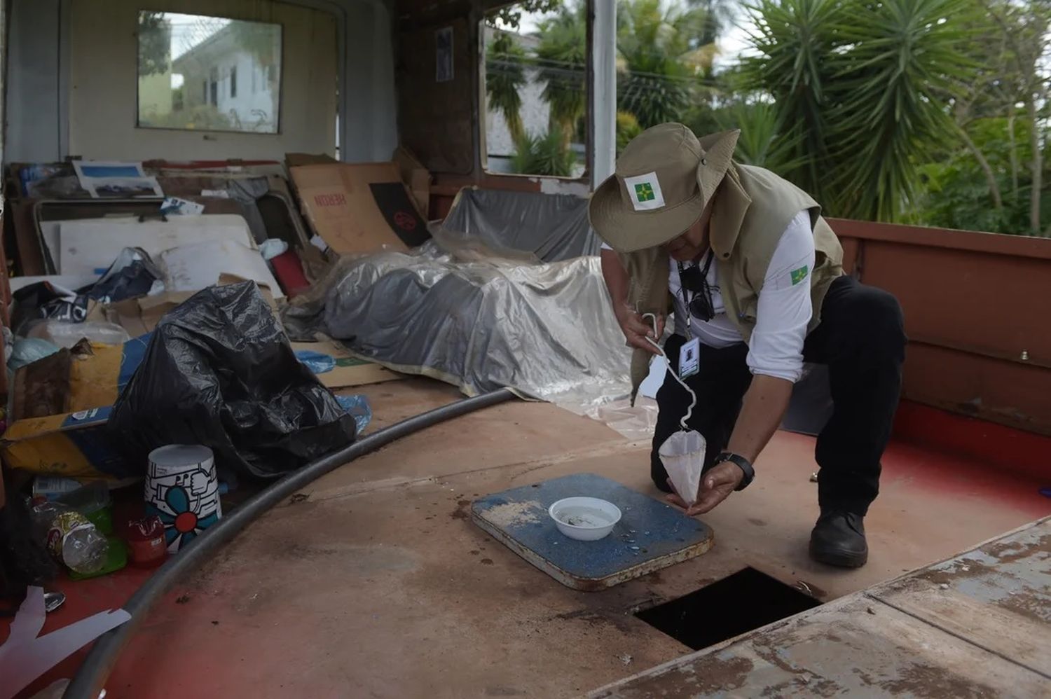 Un trabajador de vigilancia ambiental inspecciona un barco durante el combate contra el mosquito Aedes aegypti en Brasil.