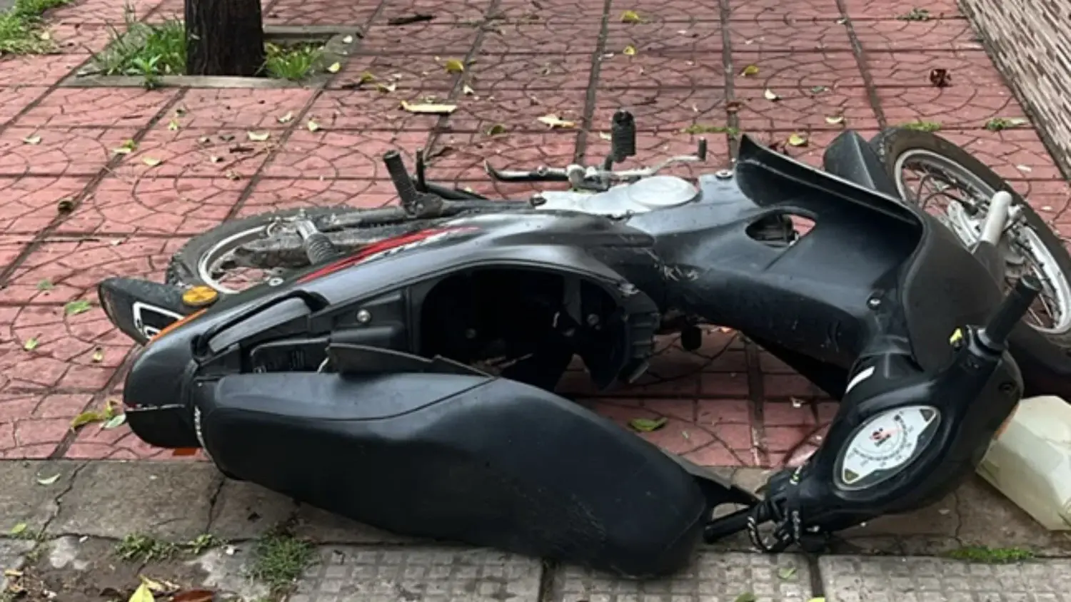 La motocicleta negra quedó tendida sobre la vereda tras el fuerte impacto contra el portón de una vivienda.